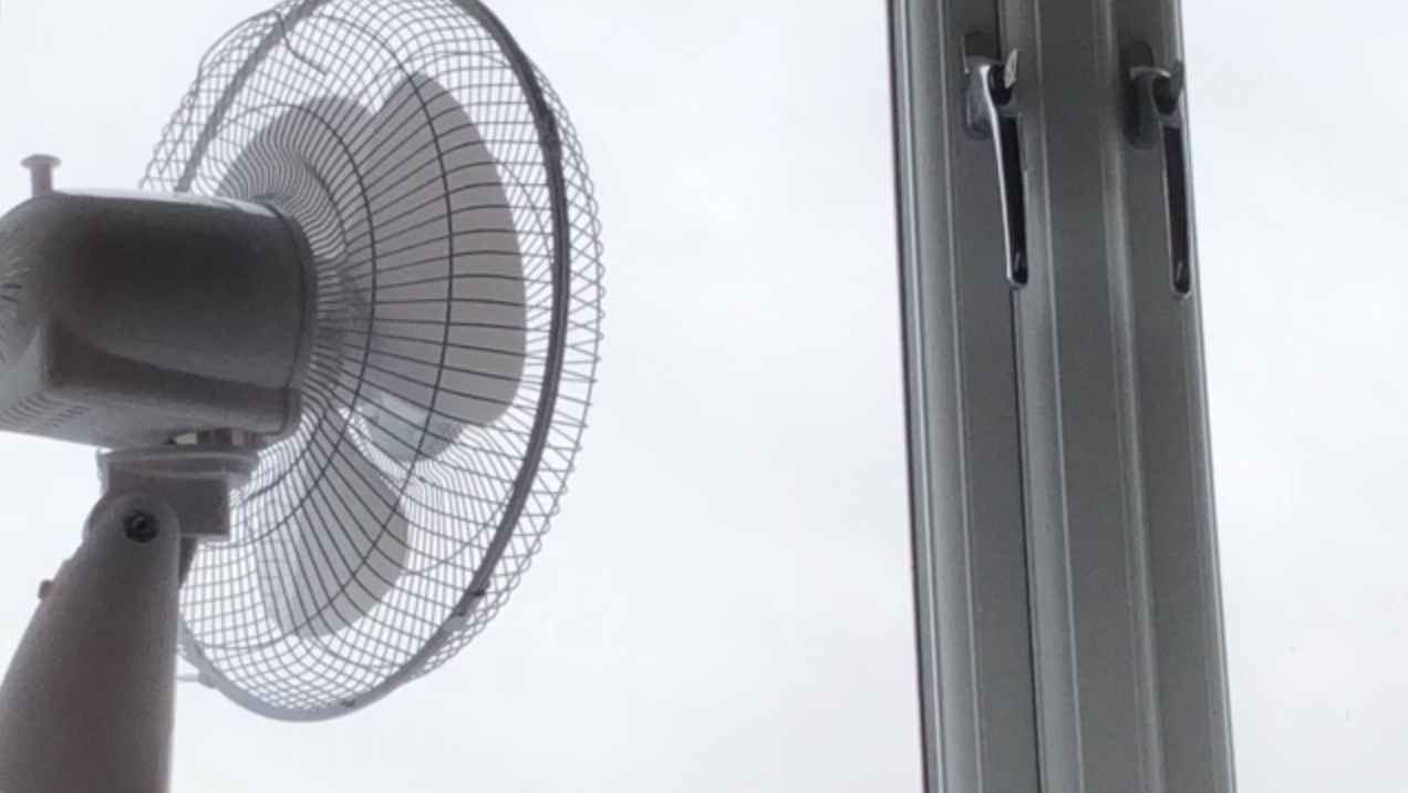 electric desk fan in front of a window